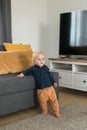Caucasian baby newborn infant making first steps. Cute toddler kid child son boy learning walking creeping on living room. Royalty Free Stock Photo
