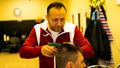 Caucasian barber cutting his client's hair.