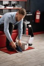 caucasian bearded man chooses hiking shoes while sitting in fitting room of modern sports store. Puts on shoes and Royalty Free Stock Photo