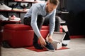 caucasian bearded man chooses hiking shoes while sitting in fitting room of modern sports store. Puts on shoes and Royalty Free Stock Photo