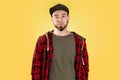 Caucasian bearded man, wearing a black cap and checked shirt. Hipster. Yellow background. Copy space Royalty Free Stock Photo