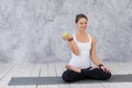 Caucasian beautiful healthy athletic sportive girl eat green apple after the training and looking at camera Royalty Free Stock Photo