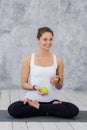 Caucasian beautiful healthy athletic sportive girl eat green apple after the training and looking at camera Royalty Free Stock Photo