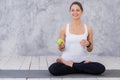 Caucasian beautiful healthy athletic sportive girl eat green apple after the training and looking at camera Royalty Free Stock Photo