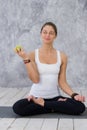 Caucasian beautiful healthy athletic sportive girl eat green apple after the training and looking at camera Royalty Free Stock Photo