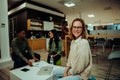Caucasian woman smiling taking lunch break sitting in cafeteria while colleagues cover work the week sitting on comfy Royalty Free Stock Photo