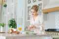 Caucasian beautiful woman preparing fresh salad ripe strawberries and arugula