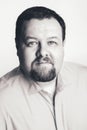 Caucasian big fat stout business man with blue eyes looking directly in camera in studio on light background