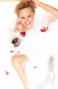 Caucasian Blond Female in Foamy Bathtub Filled with Flowery Petals Relaxing