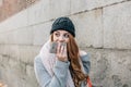 Caucasian blond girl carrying shopping bags, goes talking with her mobile phone while walking on the street Royalty Free Stock Photo