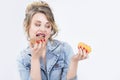 Caucasian Blond Girl Eating Two Big Doughnuts in Hands. Royalty Free Stock Photo