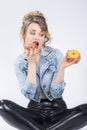 Caucasian Blond Girl Eating Two Big Doughnuts in Hands. Royalty Free Stock Photo