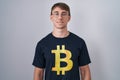 Caucasian blond man wearing bitcoin t shirt with a happy and cool smile on face