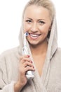 Caucasian Blond woman With Brilliant Natural Smile Cleaning Teeth using Modern Electric Toothbrush Royalty Free Stock Photo