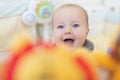 Caucasian blonde baby five months old lying on bed at home. Kid wearing cute clothing trendy colors: ultimate gray and Royalty Free Stock Photo