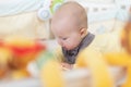 Caucasian blonde baby five months old lying on bed at home. Kid wearing cute clothing trendy colors: ultimate gray and Royalty Free Stock Photo