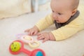 Caucasian blonde baby five months old lying on bed at home. Kid wearing cute clothing trendy colors: ultimate gray and Royalty Free Stock Photo