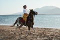 Caucasian blonde girl riding horse at sunset beach Royalty Free Stock Photo