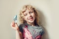 Caucasian blonde girl showing her missing tooth in mouth and holding money from tooth fairy. Proud child kid showing lost tooth.