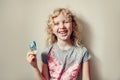 Caucasian blonde girl showing her missing tooth in mouth and holding money from a tooth fairy. Proud child kid showing lost tooth