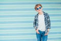 Caucasian blonde hair 12 year old teenager boy Fashion portrait dressed white t-shirt with checkered shirt in blue sunglasses with Royalty Free Stock Photo