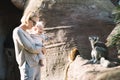 Caucasian blonde mother holding her infant baby boy child in her lap watching ring-tailed lemur in zoo. Happy family Royalty Free Stock Photo