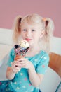 Caucasian blonde preschool girl child with blue eyes holding ice cream in large waffle cone Royalty Free Stock Photo