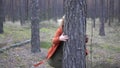 Caucasian blonde woman playing hide and seek in the forest.