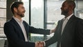 Caucasian boss hr manager man shake hand of African American candidate partner client making deal hiring thanking for Royalty Free Stock Photo