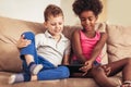 Caucasian boy and African American girl at home using tablet Royalty Free Stock Photo