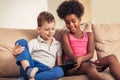 Caucasian boy and African American girl using tablet. Royalty Free Stock Photo