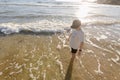 A boy standing in the shallows at the beach Royalty Free Stock Photo