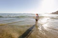 A boy standing in the shallows at the beach Royalty Free Stock Photo