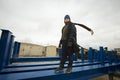 caucasian boy in a coat and hat with a scarf and walks through pipes in an industrial area Royalty Free Stock Photo