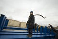 caucasian boy in a coat and hat with a scarf and walks through pipes in an industrial area Royalty Free Stock Photo