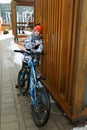 A Caucasian boy dressed in a winter jacket walks with a bicycle around the city Royalty Free Stock Photo