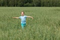 Caucasian boy on the field with a oats is running with his arms outstretched. Royalty Free Stock Photo