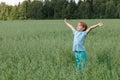 Caucasian boy on the field with a oats stands with his arms outstretched. Happy child Royalty Free Stock Photo