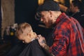 Caucasian boy getting haircut in barbershop indoor