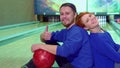 Boy and girl sitting on the floor at the bowling alley