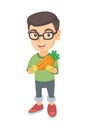 Caucasian boy in glasses holding fresh carrot.