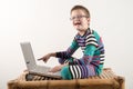 A Caucasian boy with glasses tries to work with a computer and the Internet. The guy gets vivid emotions. Royalty Free Stock Photo