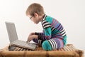 A Caucasian boy with glasses tries to work with a computer and the Internet. The guy gets vivid emotions Royalty Free Stock Photo