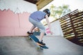 Caucasian boy in a helmet does tricks on a skateboard on a playground for skateboarding outside. A child skateboarder rides a