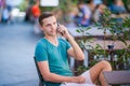 Caucasian boy is holding cellphone outdoors on the street. Man using mobile smartphone. Royalty Free Stock Photo