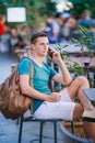 Caucasian boy is holding cellphone outdoors on the street. Man using mobile smartphone. Royalty Free Stock Photo