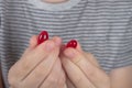 A Caucasian boy holds two red pills of a medicinal drug in his hands Royalty Free Stock Photo