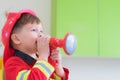 Caucasian boy kid dress up to fireman and use speaker at roll pl Royalty Free Stock Photo