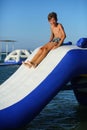 Caucasian boy of nine year old having fun at the inflatable beach aqua slide Royalty Free Stock Photo