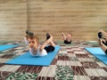 Caucasian boy and others children in white t-shirts, black shorts, swimwear stretch their back in dance classes